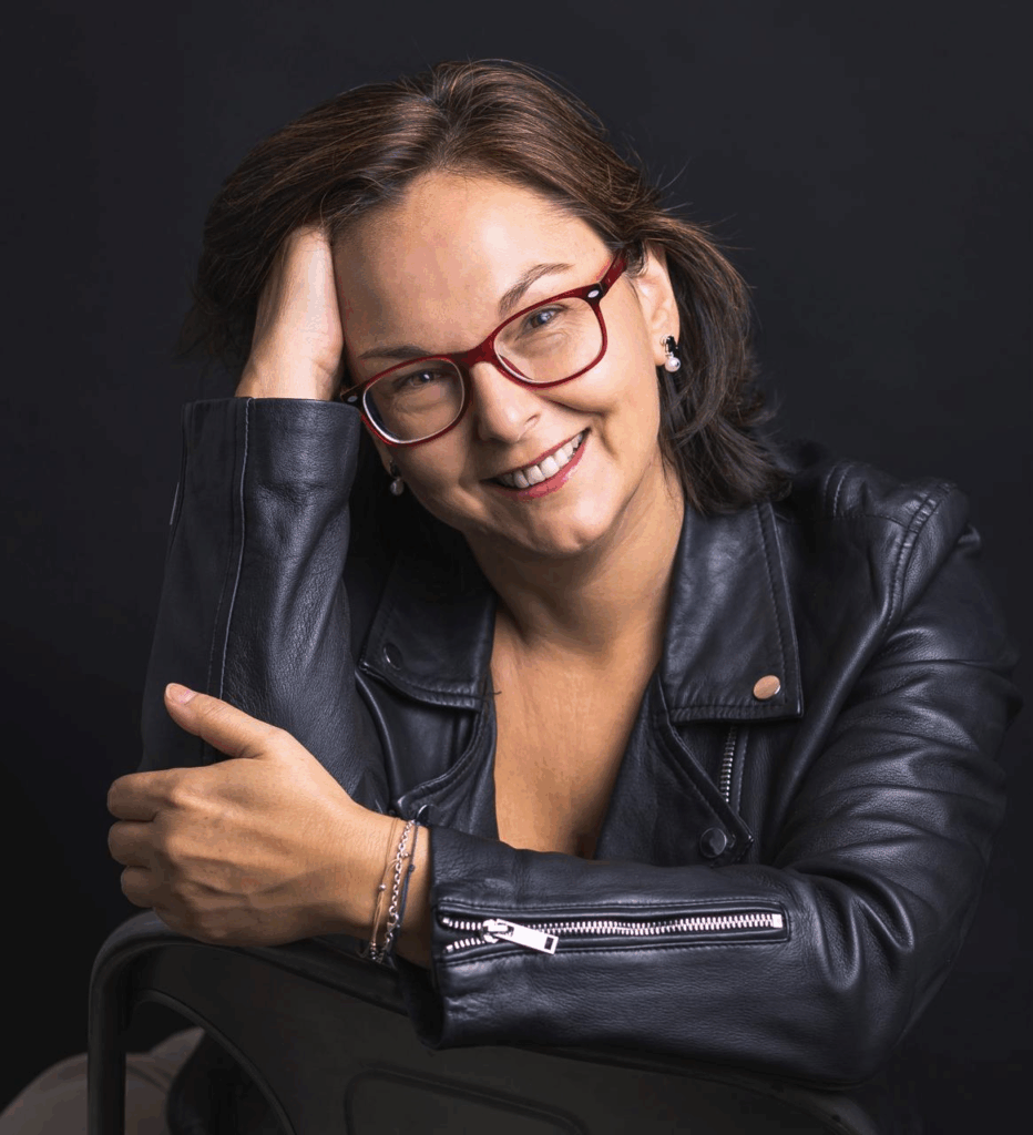 Retrato profesional de Mónica Sordo sentada en fondo negro