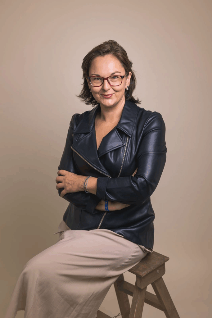 Retrato profesional de Mónica Sordo sentada en fondo blanco